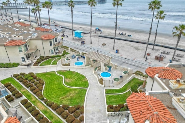 drone / aerial view with a water view and a beach view