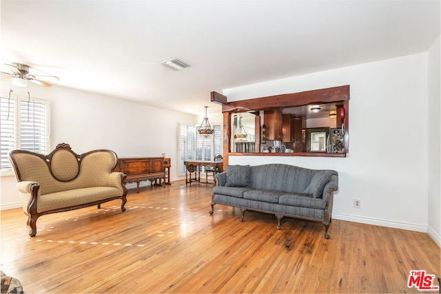 living room featuring ceiling fan, a healthy amount of sunlight, and light wood-type flooring