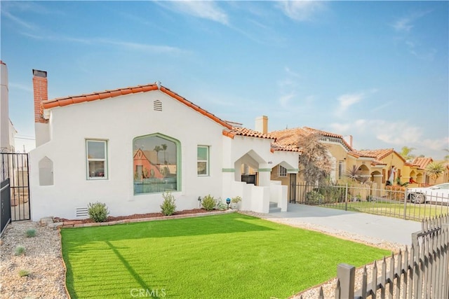 mediterranean / spanish house featuring a front lawn