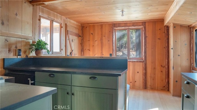 kitchen featuring a healthy amount of sunlight, wooden walls, light hardwood / wood-style flooring, and wooden ceiling