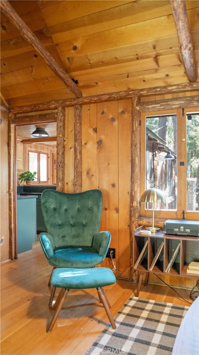 living area featuring wood walls, vaulted ceiling with beams, wood ceiling, and wood-type flooring