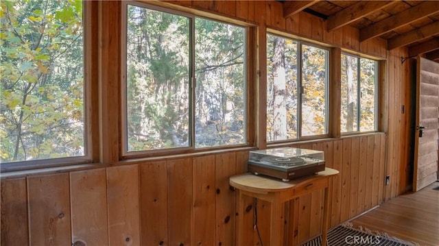 unfurnished sunroom with plenty of natural light and beamed ceiling