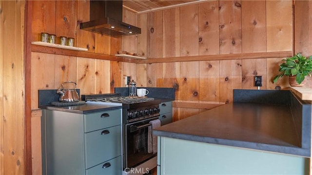 kitchen featuring stainless steel range, wood ceiling, wooden walls, and range hood