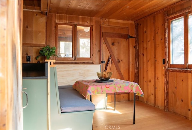 unfurnished bedroom featuring wood ceiling, wood walls, and light hardwood / wood-style floors