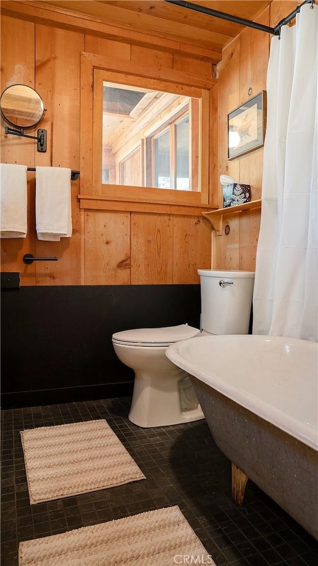 bathroom featuring toilet, wood walls, wood ceiling, and tile patterned flooring