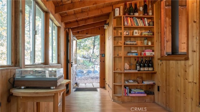 interior space with wood ceiling, light hardwood / wood-style floors, vaulted ceiling with beams, and wooden walls