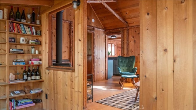 interior space with hardwood / wood-style flooring, a wood stove, and vaulted ceiling