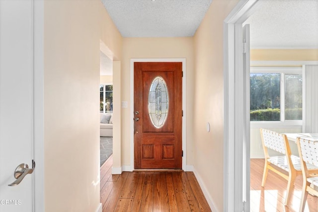 doorway to outside featuring a textured ceiling and hardwood / wood-style floors