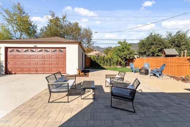 view of patio featuring a garage and a fire pit