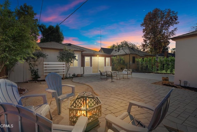 patio terrace at dusk featuring an outdoor fire pit