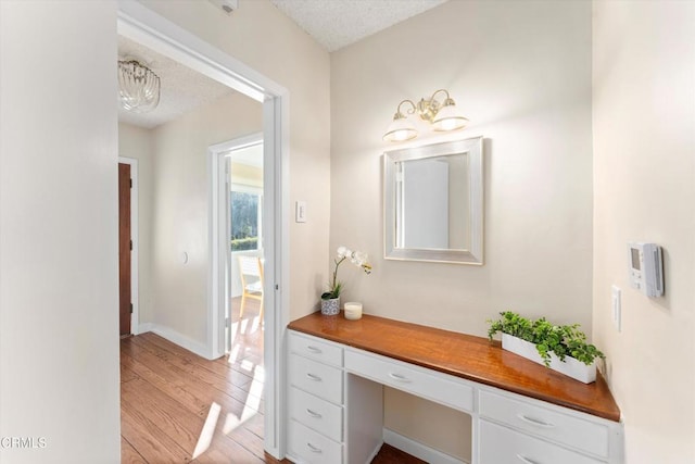 bathroom featuring wood-type flooring and a textured ceiling