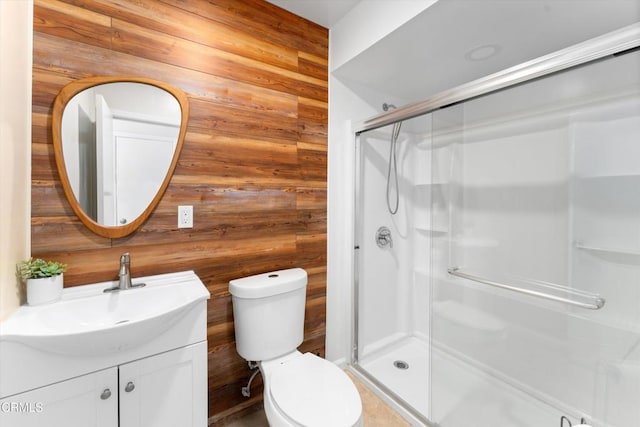 bathroom with walk in shower, vanity, toilet, and wooden walls