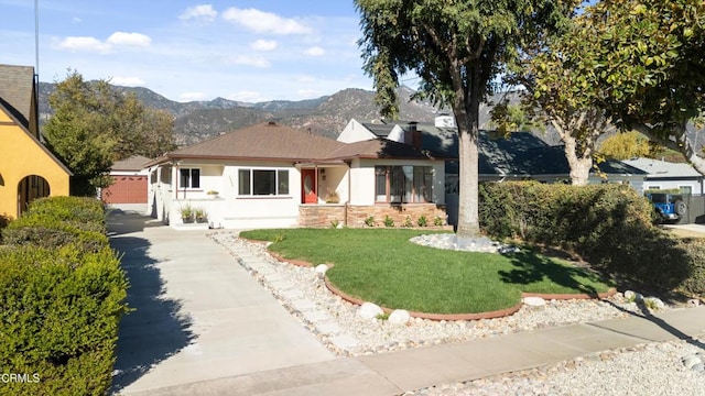 view of front facade featuring a front lawn, a garage, and a mountain view