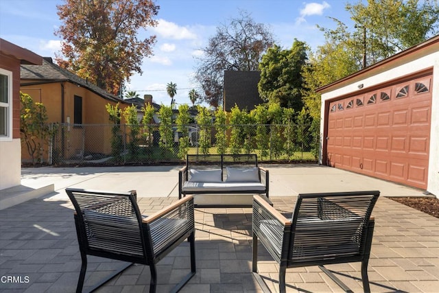 view of patio with an outdoor living space and a garage