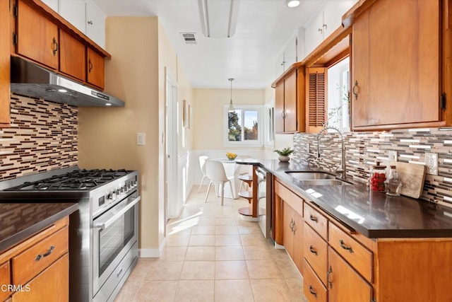 kitchen with light tile patterned floors, appliances with stainless steel finishes, backsplash, pendant lighting, and sink