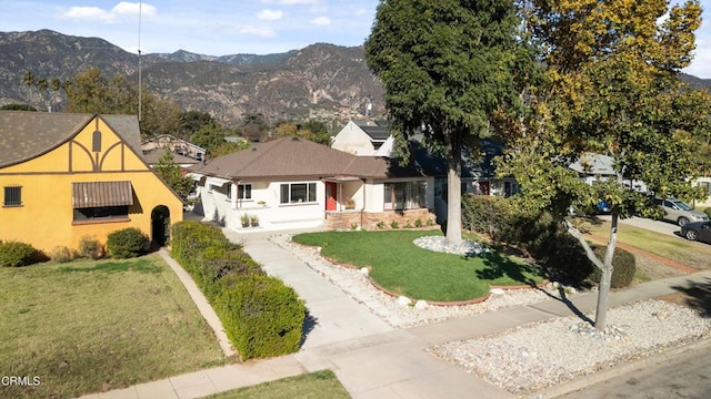 view of front of house featuring a mountain view and a front lawn