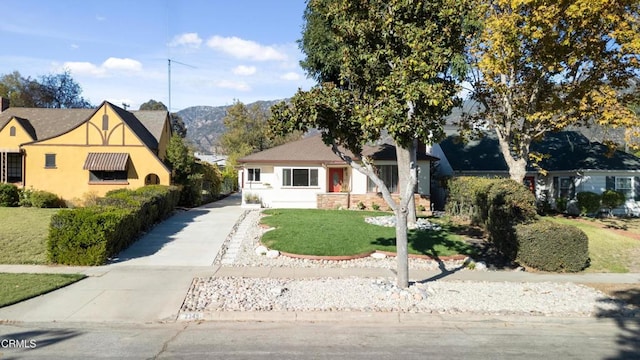 view of front of home with a mountain view and a front lawn