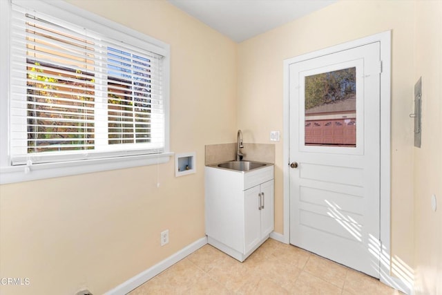 laundry area with cabinets, light tile patterned floors, hookup for a washing machine, and sink