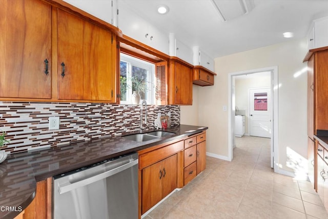 kitchen with washer / dryer, dishwasher, backsplash, and sink