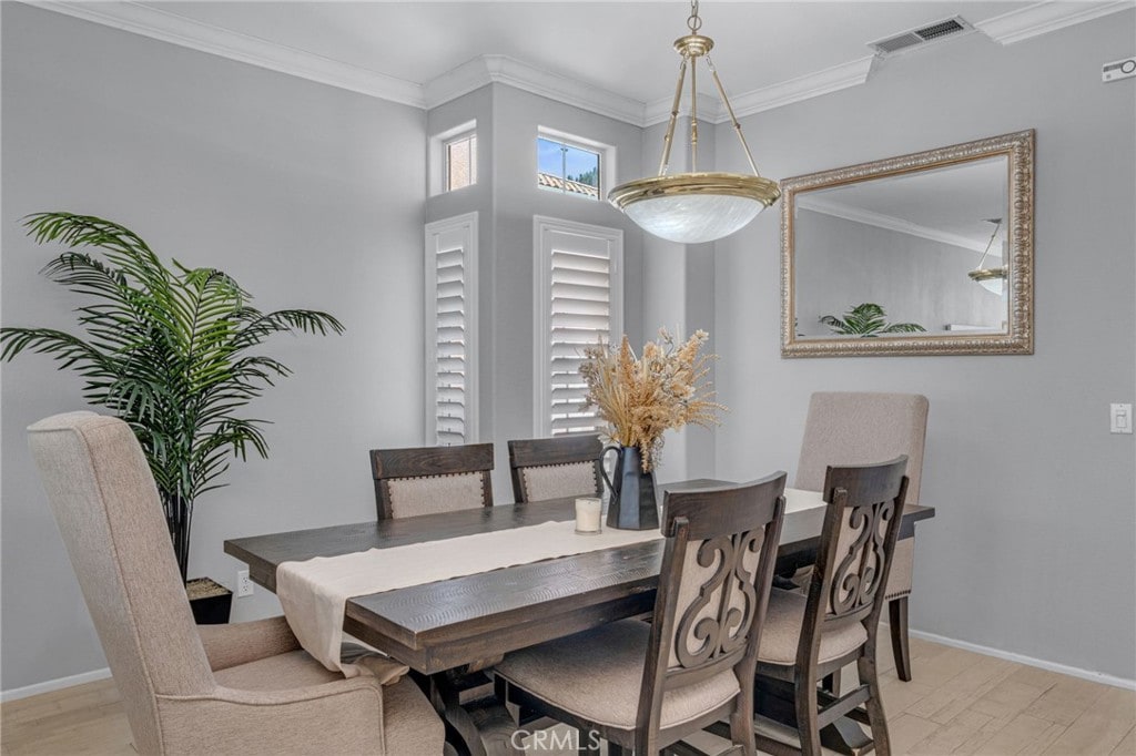 dining room featuring light hardwood / wood-style flooring and ornamental molding