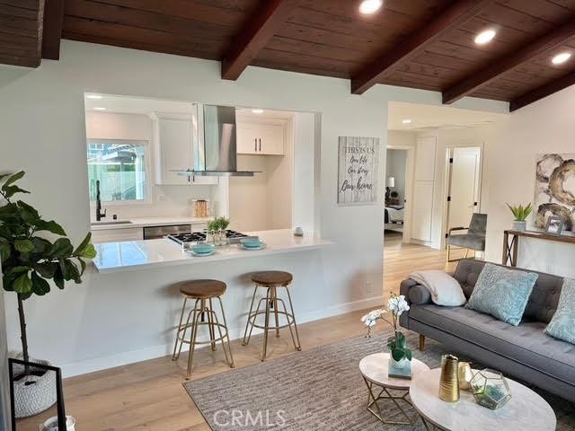 interior space with exhaust hood, wood ceiling, light hardwood / wood-style flooring, and white cabinets