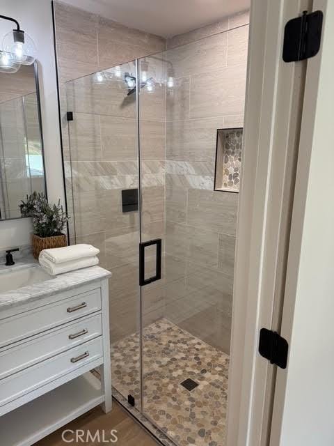 bathroom featuring vanity, hardwood / wood-style flooring, and an enclosed shower