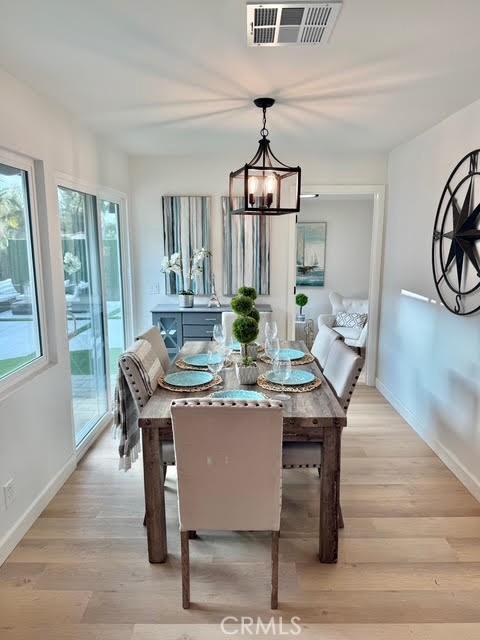 dining area with a chandelier and light hardwood / wood-style flooring