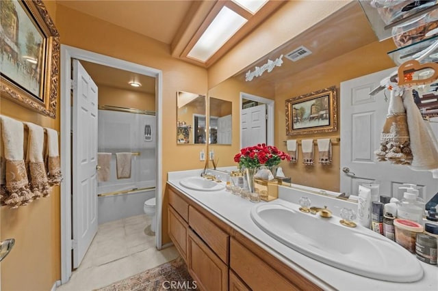 full bathroom with tile patterned floors, combined bath / shower with glass door, vanity, and toilet