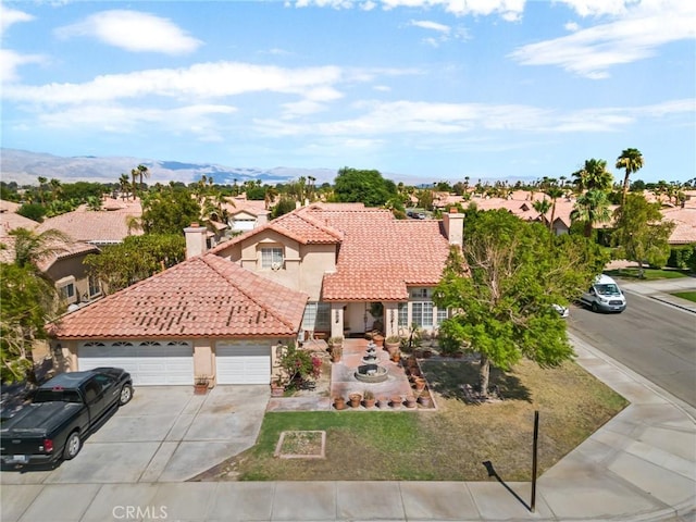 mediterranean / spanish-style home with a mountain view and a garage