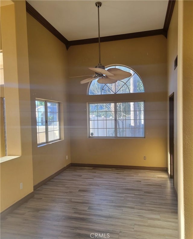 empty room with ceiling fan, ornamental molding, and hardwood / wood-style floors