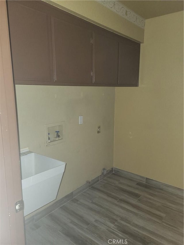 clothes washing area featuring washer hookup, cabinets, light hardwood / wood-style flooring, and sink