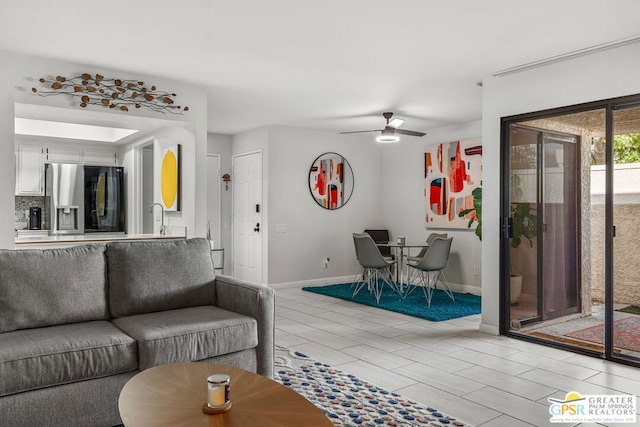 living room featuring ceiling fan and sink