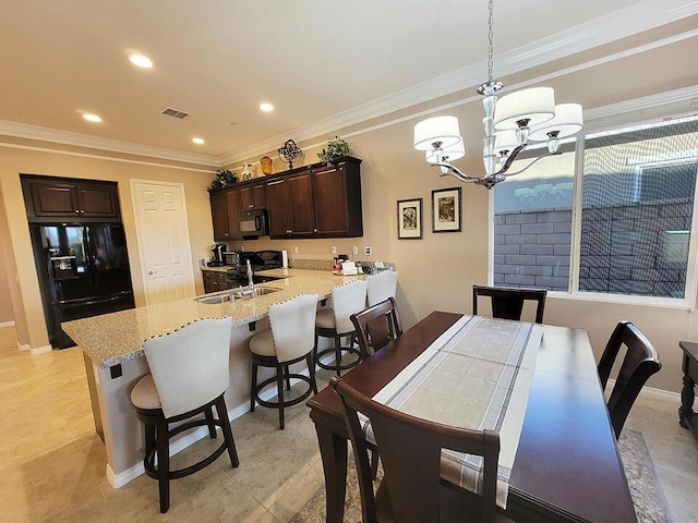 dining area with sink, crown molding, and a chandelier