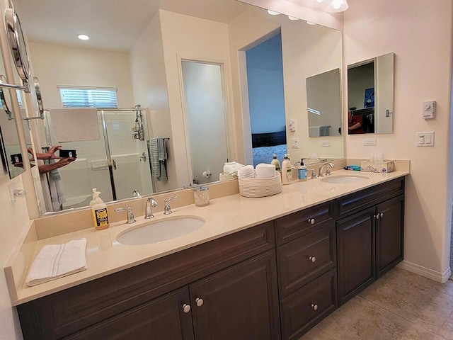 bathroom with walk in shower, vanity, and tile patterned floors