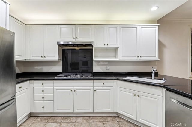 kitchen featuring stainless steel appliances, light tile patterned flooring, ornamental molding, white cabinets, and sink