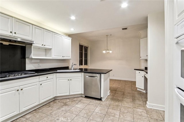 kitchen with decorative light fixtures, white cabinetry, stainless steel appliances, sink, and kitchen peninsula