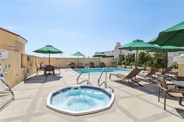 view of swimming pool featuring a patio area and a hot tub