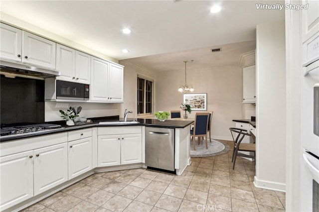 kitchen featuring decorative light fixtures, white cabinets, sink, and stainless steel appliances