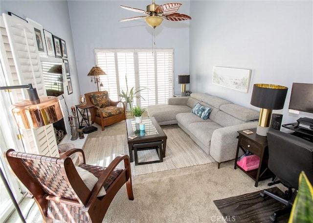 carpeted living room with ceiling fan