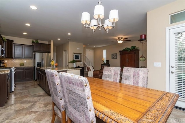 dining area with sink and ceiling fan with notable chandelier