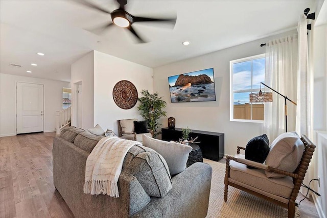 living room with ceiling fan and light hardwood / wood-style flooring