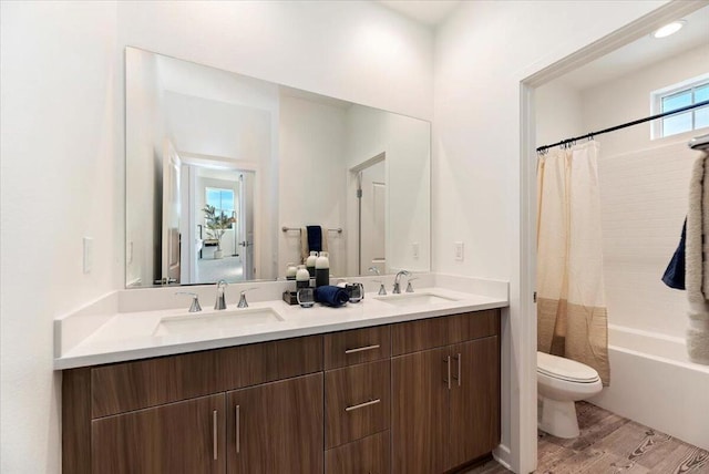 full bathroom featuring toilet, shower / bath combination with curtain, wood-type flooring, and vanity