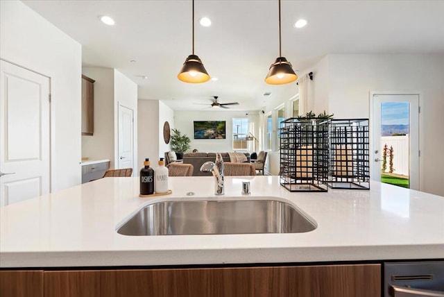 kitchen with ceiling fan, sink, and decorative light fixtures