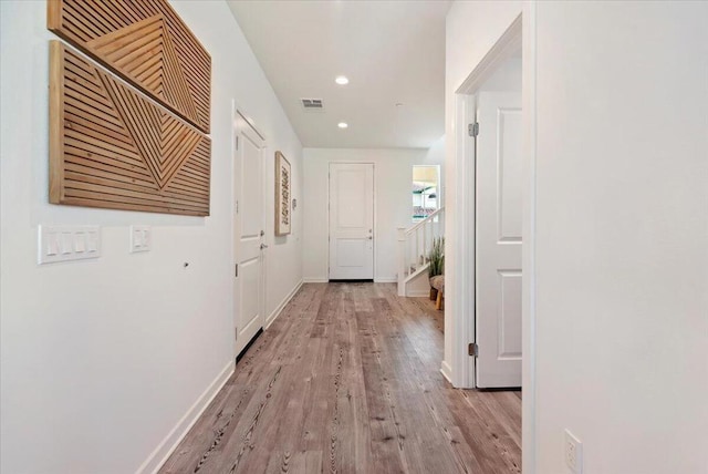 corridor with light hardwood / wood-style floors