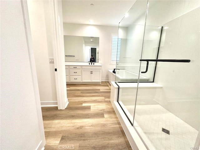 bathroom with vanity, wood-type flooring, and shower with separate bathtub