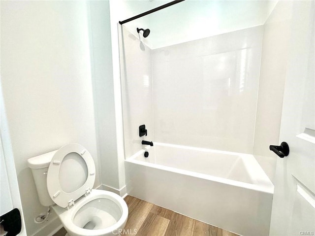 bathroom featuring toilet, bathing tub / shower combination, and wood-type flooring