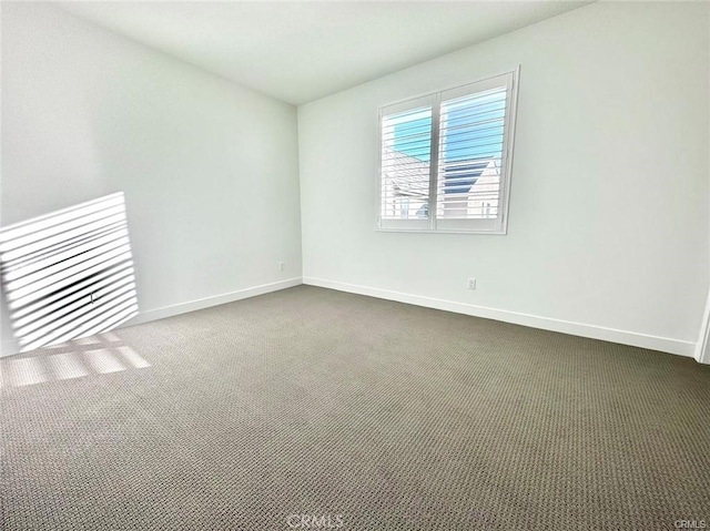 spare room featuring dark carpet