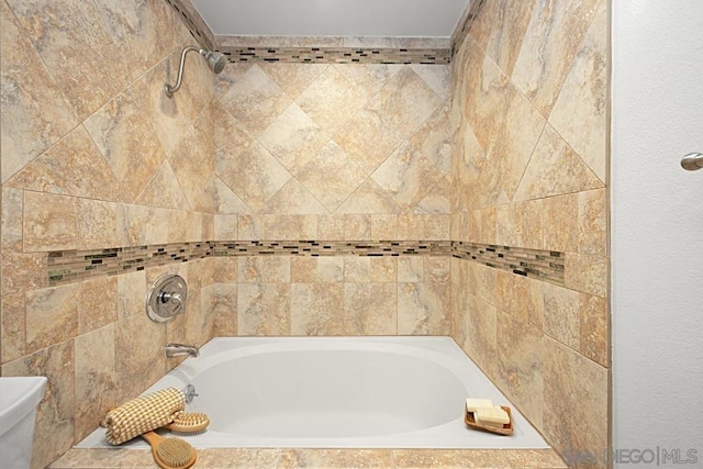 bathroom featuring toilet and tiled shower / bath combo