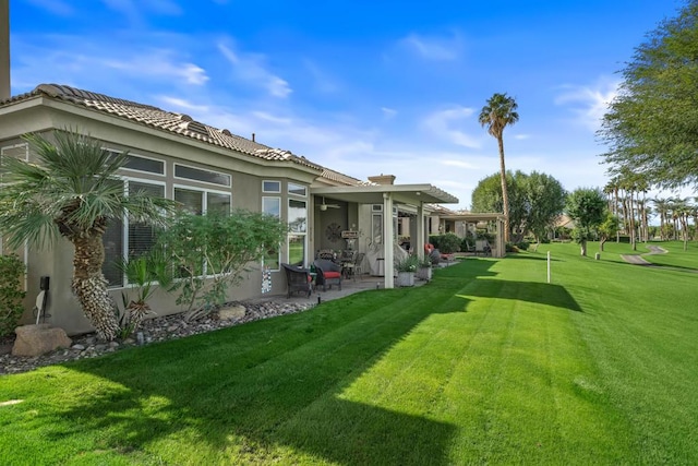 back of property featuring a lawn and a patio area