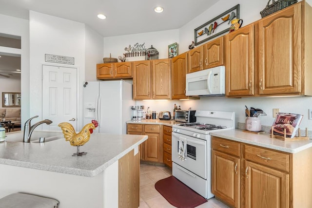 kitchen featuring sink, white appliances, a kitchen island with sink, and light tile patterned floors